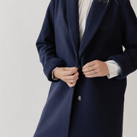 Close up view of woman wearing a navy blue wool coat