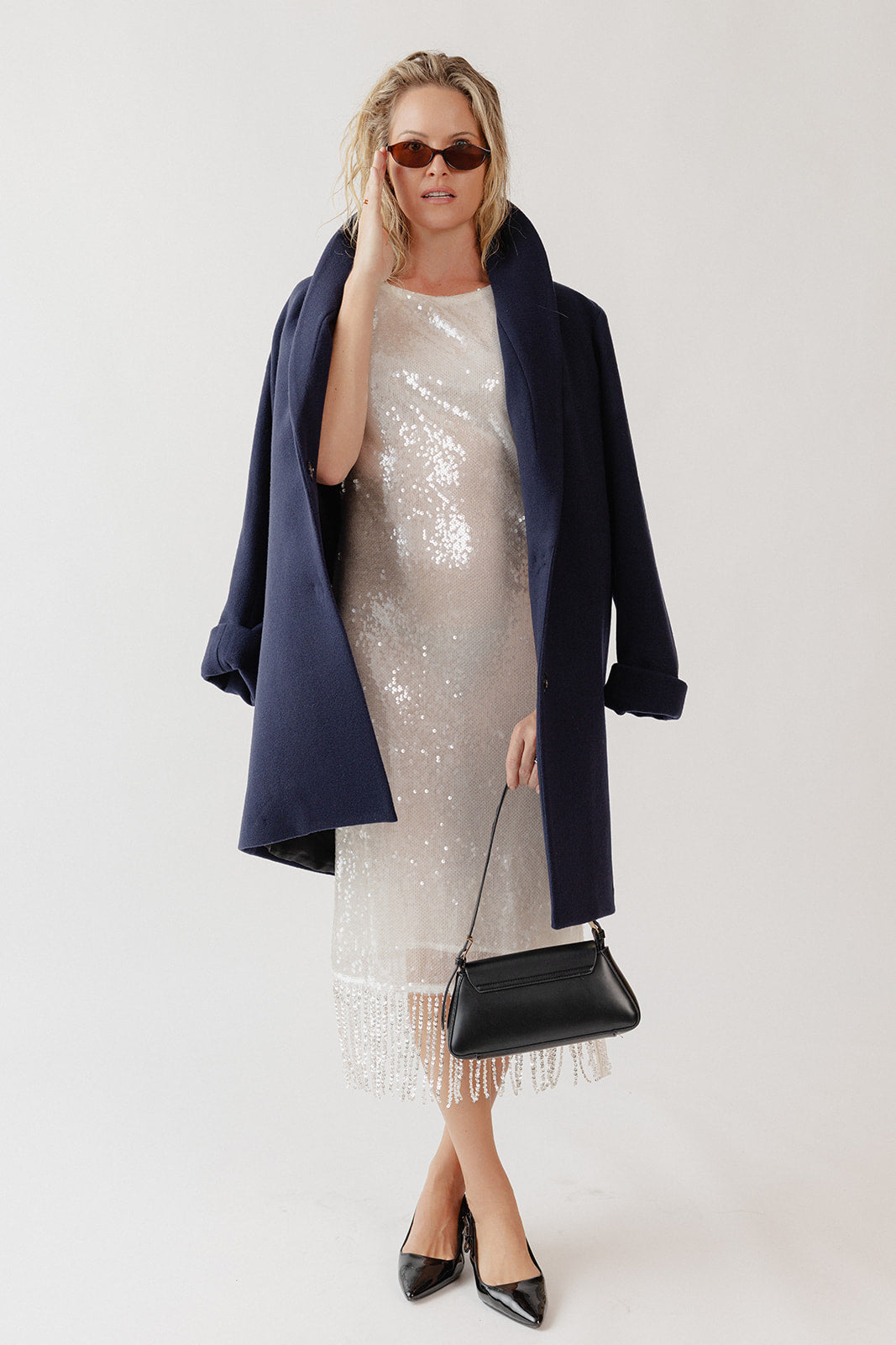 Woman wearing a wool coat over a holiday party dress