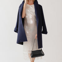 Woman wearing a wool coat over a holiday party dress