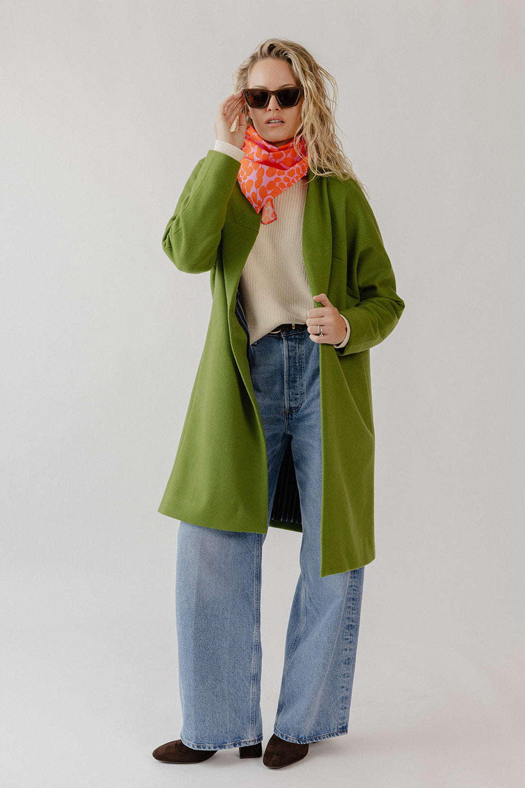 Woman wearing a knee-length green wool coatigan with hidden magnetic closure