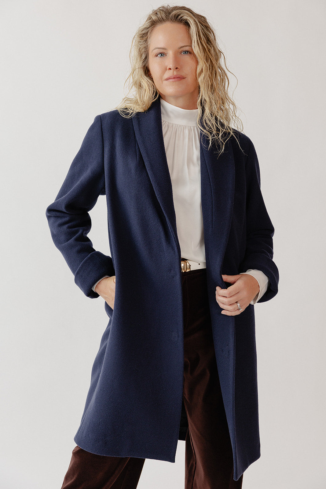 Woman wearing a Wool Navy Blue Coat at knee length.
