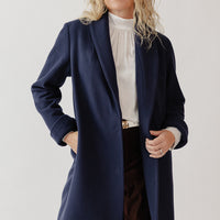 Woman wearing a Wool Navy Blue Coat at knee length.
